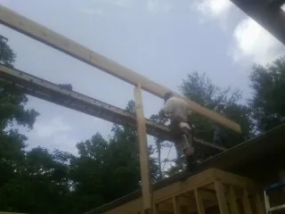 Carpenter setting a ridge beam over a new addition frame — Ice Dam Removal by Roofing Brothers in Plymouth